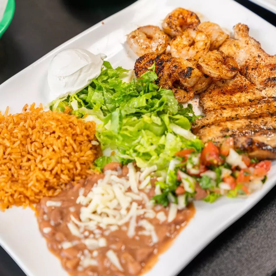 Grilled chicken and shrimp with rice, refried beans, lettuce, pico de gallo, and sour cream.