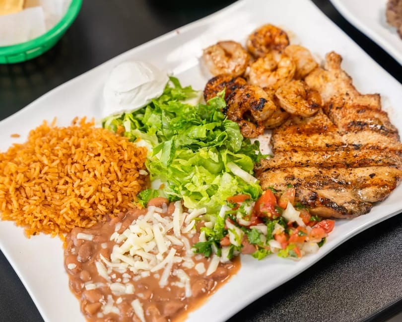 Grilled chicken and shrimp with rice, beans, lettuce, pico de gallo, and sour cream.